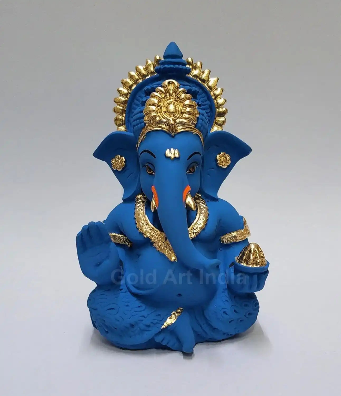 Blue terracotta Ganesha idol with Gold detailing, seated in a blessing posture, holding a modak in one hand.