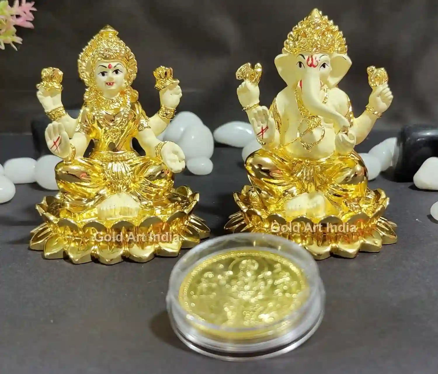 Artistic angled view of Lakshmi Ganesh Idol pair with gold-plated coin and off-white terracotta base