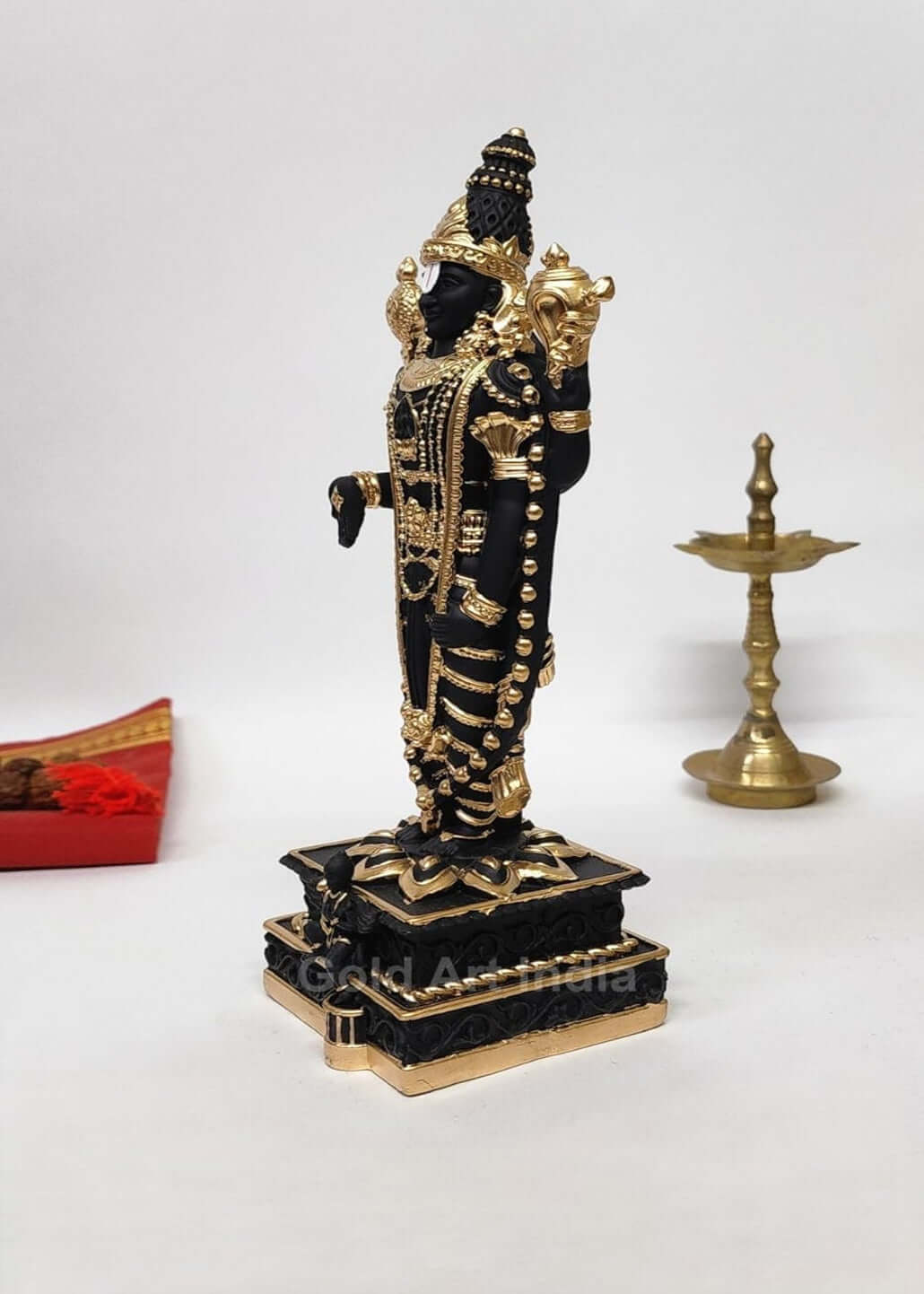 Black and gold  Plated Lord Venkateshwara idol, intricately detailed with ornate jewelry and traditional symbols, standing on a decorated pedestal.