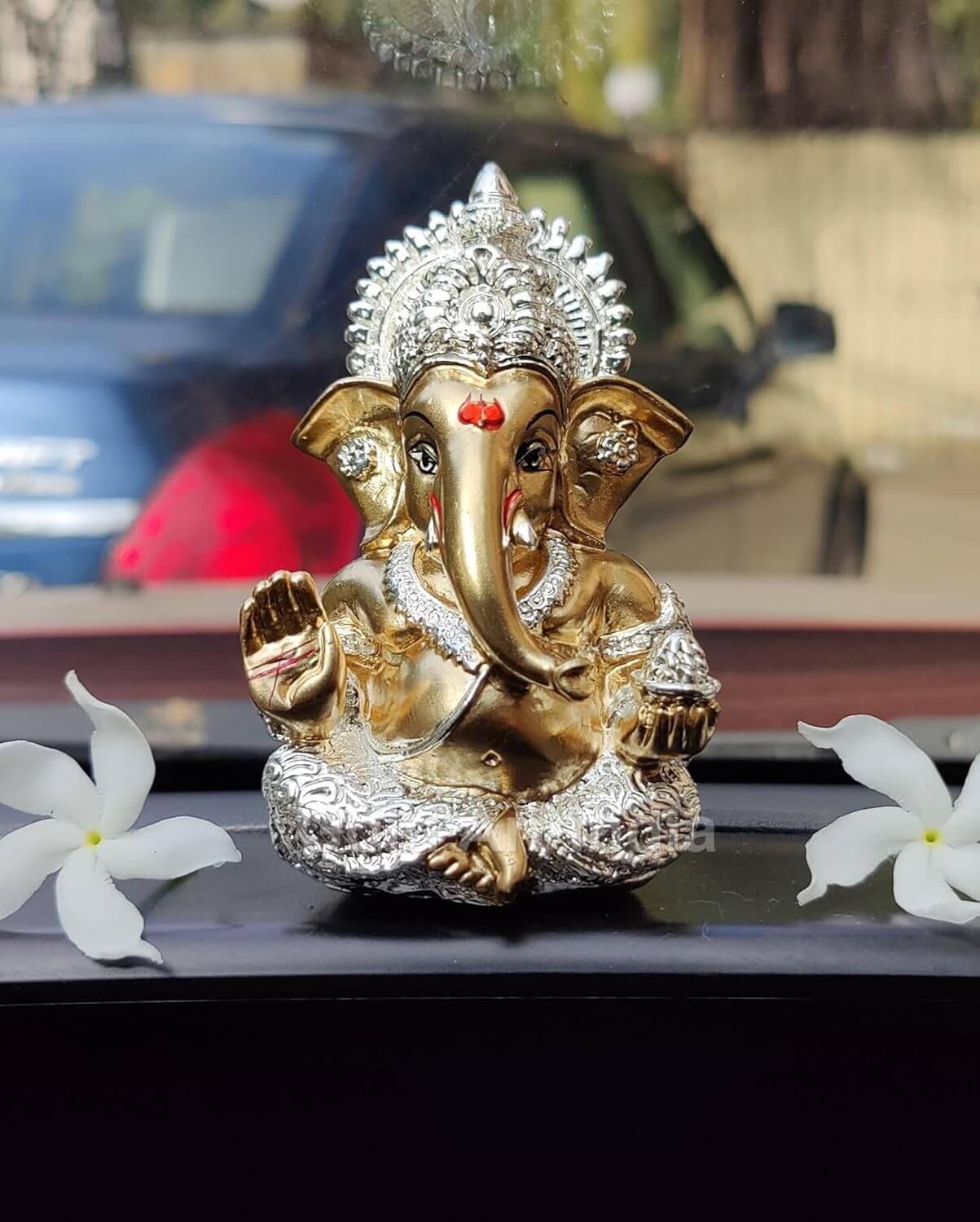 Silver Plated Antique Gold finish Ganesha idol with detailing, seated in a blessing posture, holding a modak in one hand.