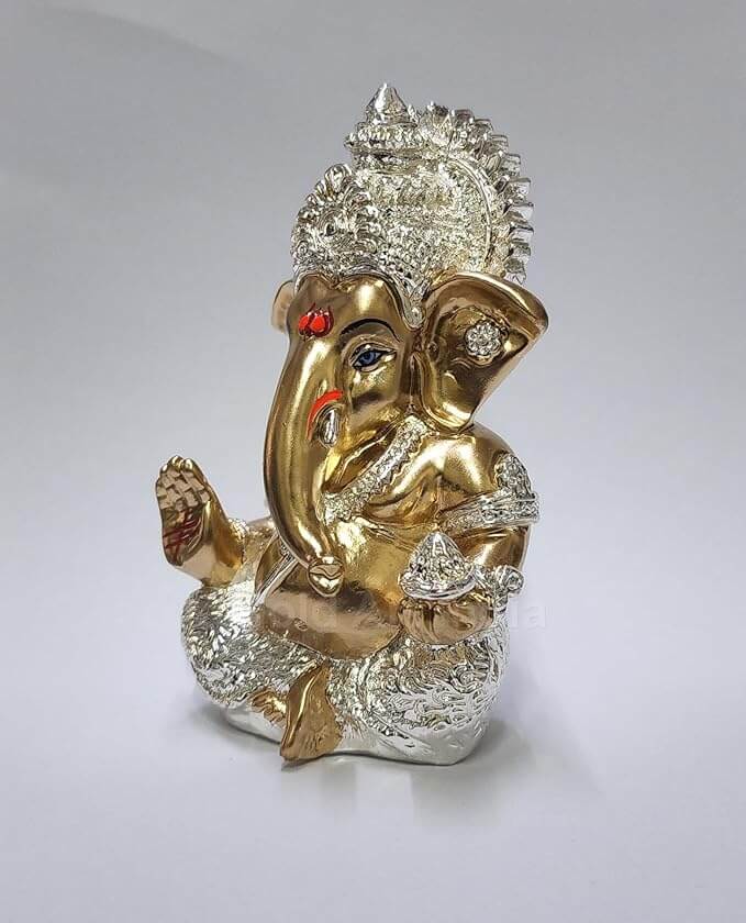Silver Plated Antique Gold finish Ganesha idol with detailing, seated in a blessing posture, holding a modak in one hand.