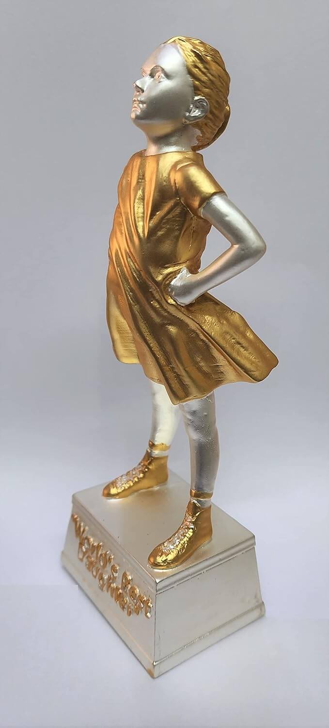 A gold and silver Plated  trophy of a confident young girl standing with her hands on her hips. The trophy has a gold dress and shoes, while the rest of the figure is silver. It stands on a silver base with the engraved text "World's Best Daughter.
