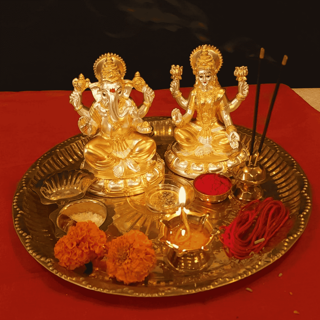 Gold-plated Laxmi and Ganesha idols on a decorative tray with flowers and diya for Diwali Puja.