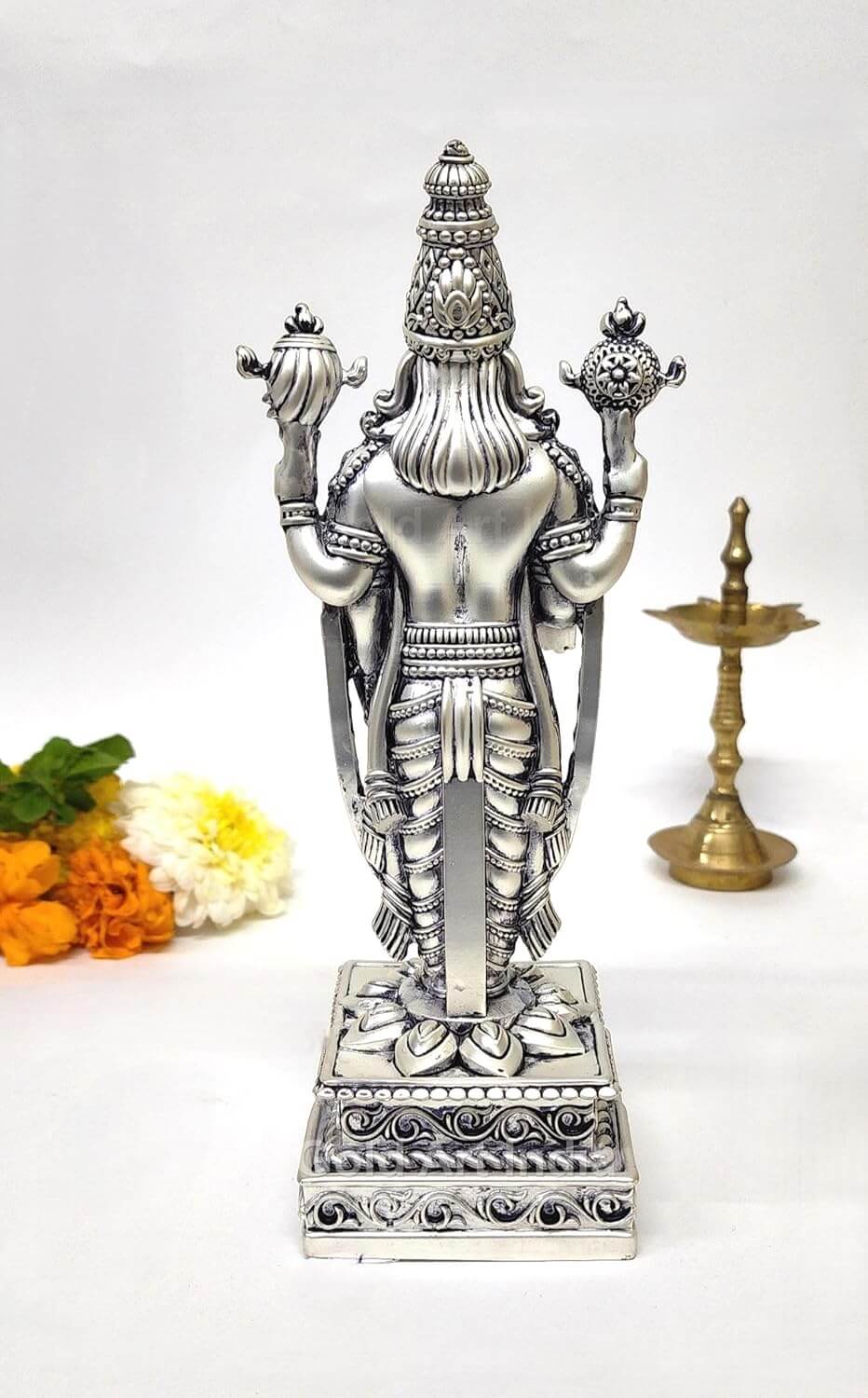 Angled view of silver-plated Tirupati Balaji idol with detailed jewelry and matte body

