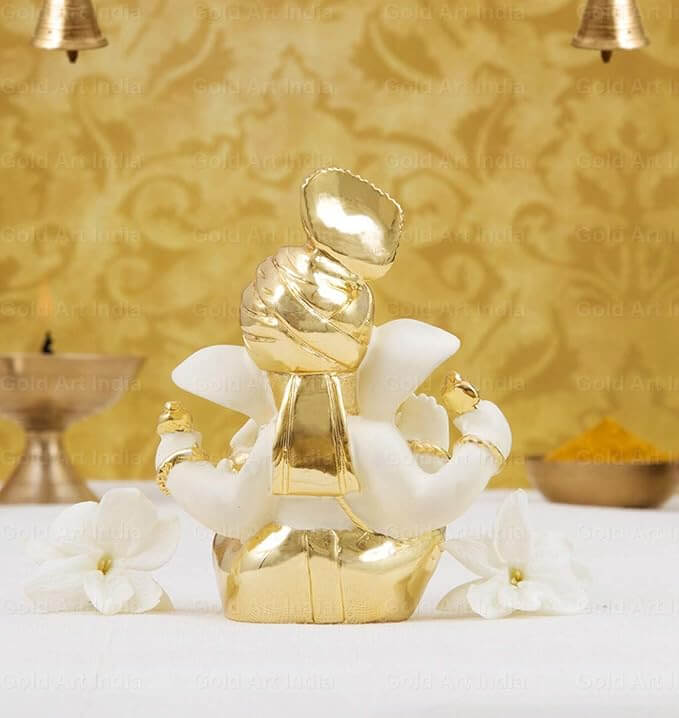 Gold plated off-white Ganesha idol for home decor and gifting, enhances festive celebrations.