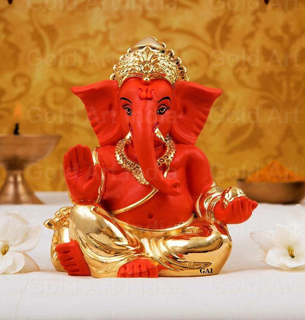 Gold plated orange Ganesha idol, perfect for home decor, car dashboard, and festive gifts. Size: 3.5x3x3 inches.