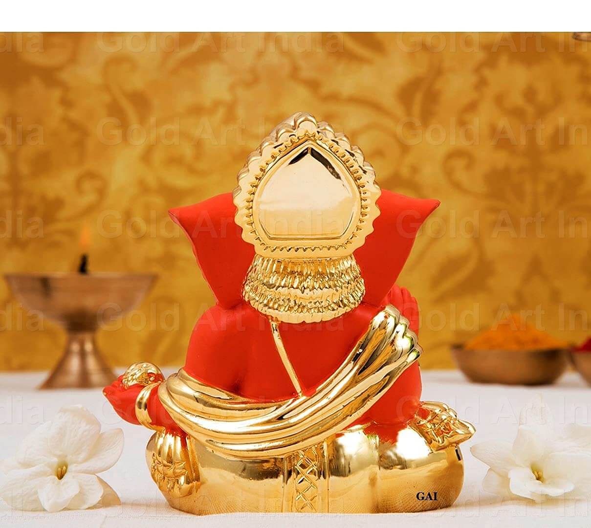 Gold plated orange Ganesha idol for home and office decor, perfect as a gift for festivals and special occasions.