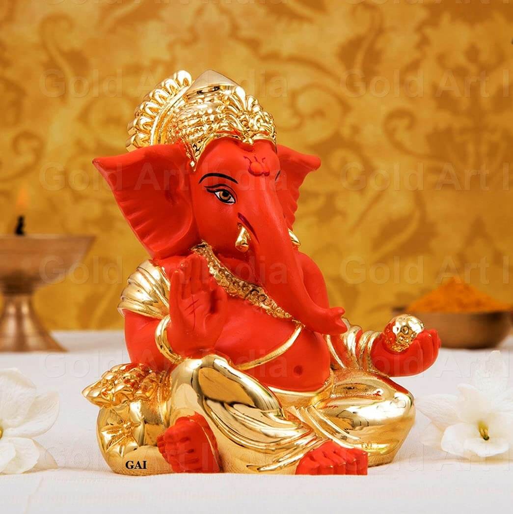 Gold plated Ganesha idol with orange finish, perfect for office and home decor, a meaningful gift for festivals.