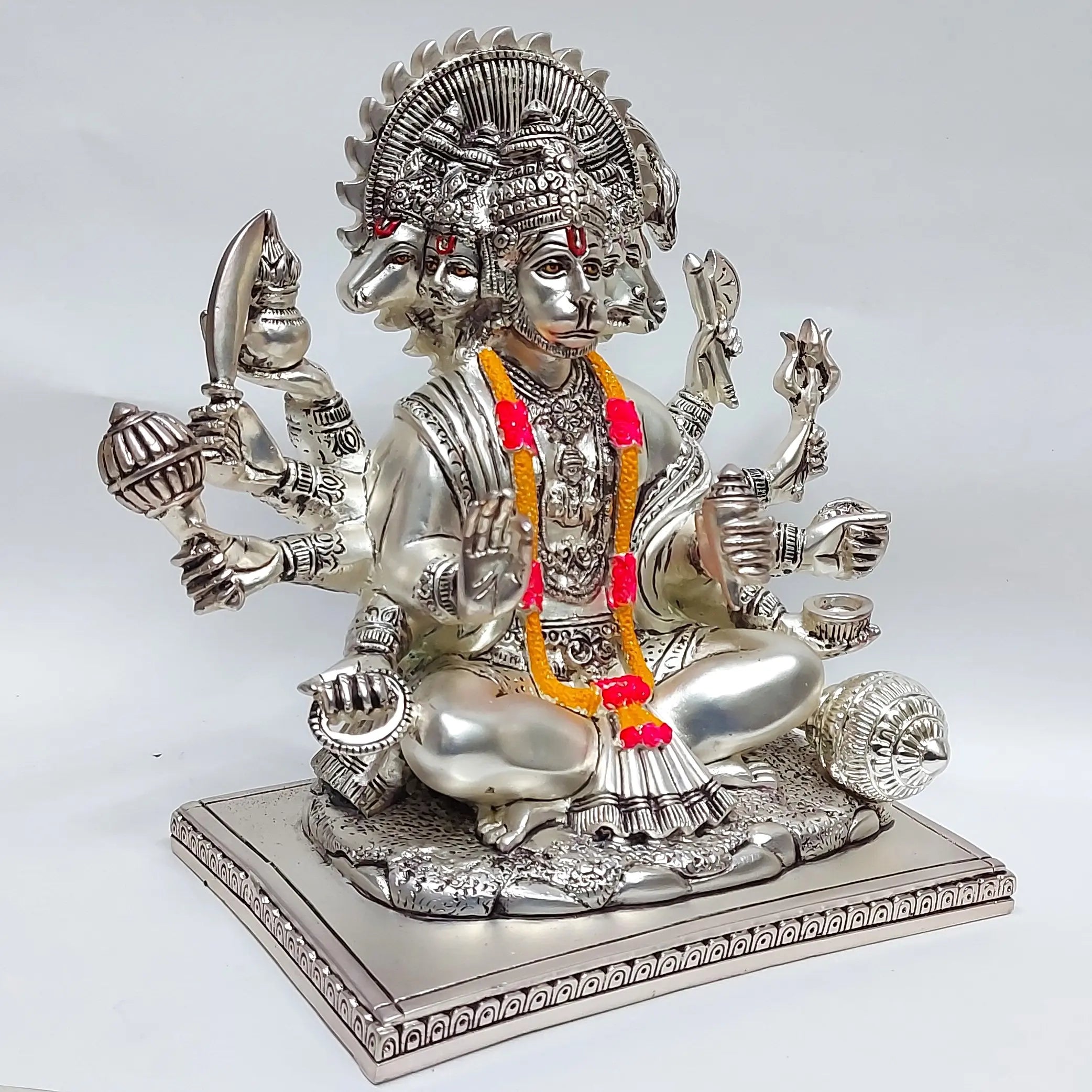 Silver plated Panchmukhi Hanuman idol seated in meditation pose with gada, trishul, and other weapons, angled view